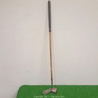 Full view of the Champion Number 10 hickory shaft putter showing the black tape on the handle and the metal putter head.