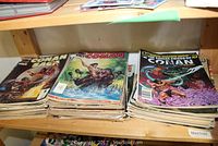Stacks of assorted Conan comic books displayed on a shelf; titles include various editions such as 'The Savage Sword of Conan'.