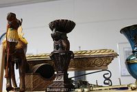 Photo showing carved wooden horse figure and ornate metal urn or decorative item