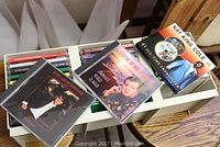 CDs displayed on top of a box, featuring Nat King Cole, Jose Luis Rodriguez, and others, showing album cover artwork and titles.