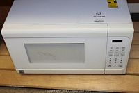 Front view of white Kenmore microwave with control buttons and display, showing overall condition and size.