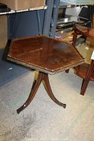 Octagonal wooden pedestal side table with curved legs and worn surface.