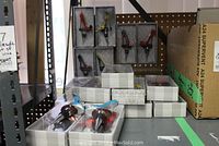 Display of multiple boxed shoe-shaped wine stoppers on shelf