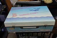 Closed original box for B Il Corredo di Sogno table linens with blue and white wave design and blue bird graphic