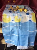 Photo showing the shower curtain with yellow rubber ducky and blue polka dot design
