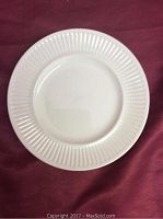 Top view of single white bread and butter plate with Athena pattern showing ribbed edge design.
