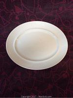 Top view of the white oval platter showing textured vertical line border design on rim.