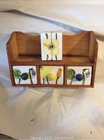Pine wood shelf with three ceramic drawers having different colored knobs and floral designs, plus two matching white ceramic salt and pepper shakers