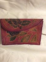 Front view of leather case showing flap closure with brown button and multicolored floral tooling on red background.