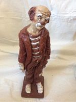Front view of the sad clown ceramic sculpture showing facial expression, clothing, and stance.