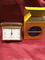 Vintage Europa travel alarm clock displayed outside its original yellow and orange cardboard box with Europa logo.