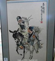 Front view of the framed ink and watercolour painting showing two figures and a donkey with Japanese calligraphy and red seal.