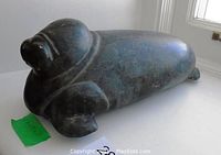 Side profile of soapstone walrus carving on white surface