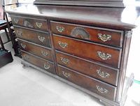 Front view showing eight drawers with shell carvings and brass pulls