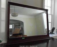 Full view of the large rectangular wooden framed mirror showing the size and reflection.