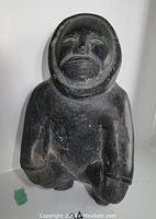 Front view of sculpture showing kneeling pose and facial detail