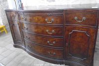 Front view of bowed front sideboard showing three lower curved drawers, three upper drawers and two side cabinet doors