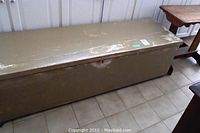 Painted wooden blanket chest, rectangular shape, showing surface wear and paint chipping.