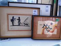 Two framed Native art prints. Left is black and white ink drawing of Inuit figures with igloo and dog signed Henry Napartuk. Right print showing colorful abstract birds titled 'Flock' signed Jackson Beardy.