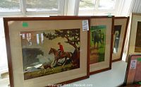 Photo of three prints leaning against a window, showing the Canadiana themes and frames with visible damage.