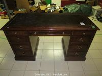 Front view of kneehole desk showing full form, pedestal drawers and leather top