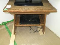 Front view of rustic oak finish side table with lower shelf and marks on tabletop