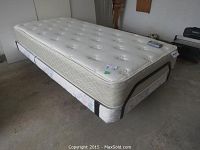 Twin size Ultramatic electric bed with white tufted mattress and supportive base.