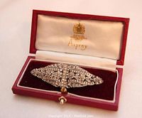 Front angled view of the double clip brooch inside the antique Asprey box showing intricate filigree and rhinestone details.