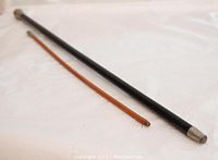 Both swagger sticks shown together, one black and longer, one brown and shorter