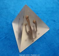 View of frosted acrylic pyramid showing molten gold bloom inside from an angle.