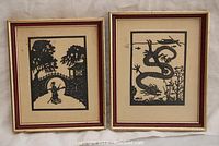Two framed paper-cut silhouettes featuring a person by an arched bridge and a Chinese dragon, both with a gold and burgundy detailed frame.