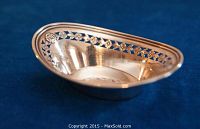 Side view of the oval sterling silver nut bowl showing the smooth polished interior and open floral decorative border.