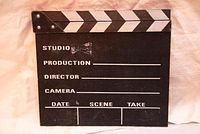 Full front view of black wooden clapper board with white printed fields