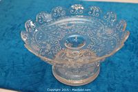 Top view showing the wheelground etched pattern, floral and scrollwork design across the surface and scalloped edge.