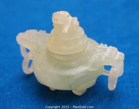 Front-side view of small carved green jade censer showing dragon motif handles and lion on lid.