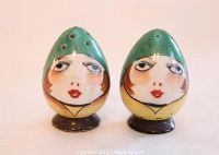 Both Noritake Art Deco flapper lady salt and pepper shakers front view, showing facial designs and green hats.