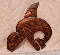 Full view of the orca wood carving showing overall shape, design, and condition