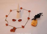 Overall display of two necklaces, ring on stand and pair of earrings