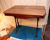 Frontal view of rectangular wood tabletop and cast iron base