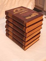 Stack of six brown cloth bound hardback volumes
