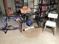 Photo showing multiple items including Weslo Cardio Glide, Body Solid weight rack, ab press machine, white medical chair, and a box of Beach Body videos on top of the weight rack.