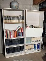 Front view of two MDF bookshelves filled with encyclopedias and assorted books, large globe on top of left shelf.