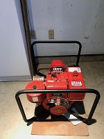 Full front view of red Homelite 4400 gas generator with black metal frame and collar enclosing the engine.