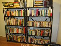 Two black metal shelving units filled with books to show size and capacity, shelving approximately 36x12x59 inches each.
