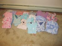 Wide view of all sleeping apparel laid out on floor showing variety of colors, patterns, and items.