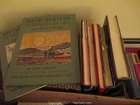 Photo showing multiple copies of Metropolitan Seminars in Art books with blue covers featuring artwork on front, produced by The Metropolitan Museum of Art.