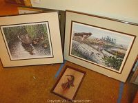 Two framed wildlife prints and one framed copper effigy on carpet floor, showing the lot items.