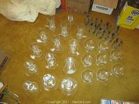 Arrangement of clear glass parfait cups and desserts dishes with vintage water glasses on a carpeted floor