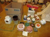 View of all items on table, including bowls, mugs, casserole dish, canister, coasters, rolling pin, slicer