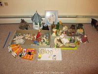 Wide shot showing collection of assorted decorative items including animal figurines, folk art, trinket boxes, and candle holders.